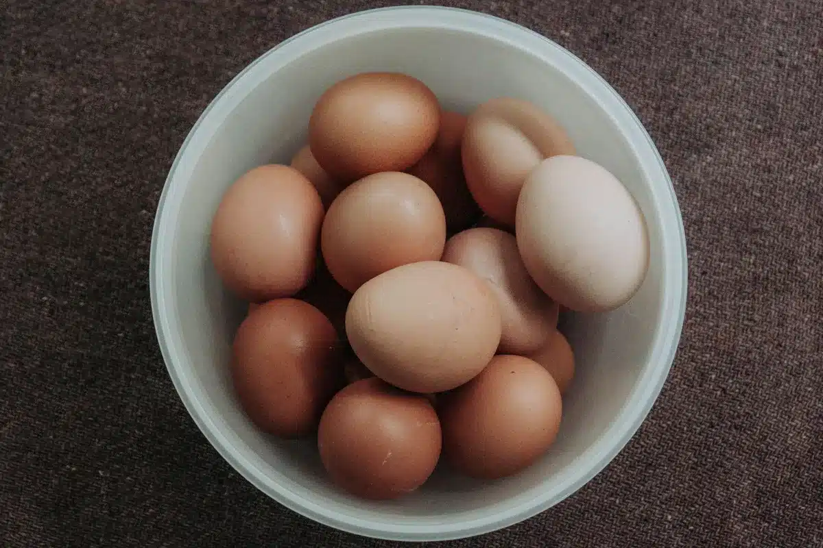 Fresh whole eggs with yolks visible, displayed next to egg whites