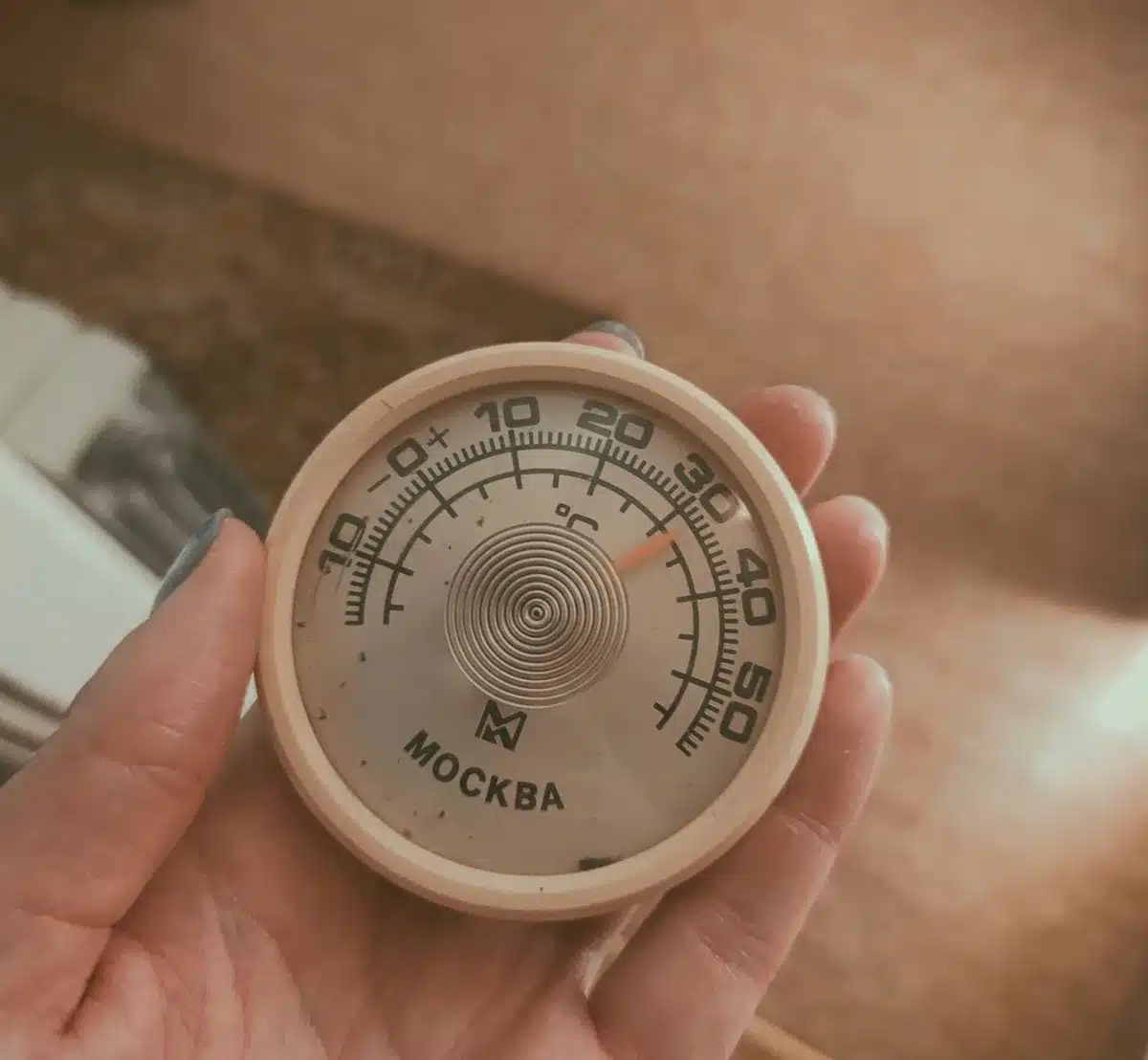 Refrigerator thermometer showing temperature reading on a shelf