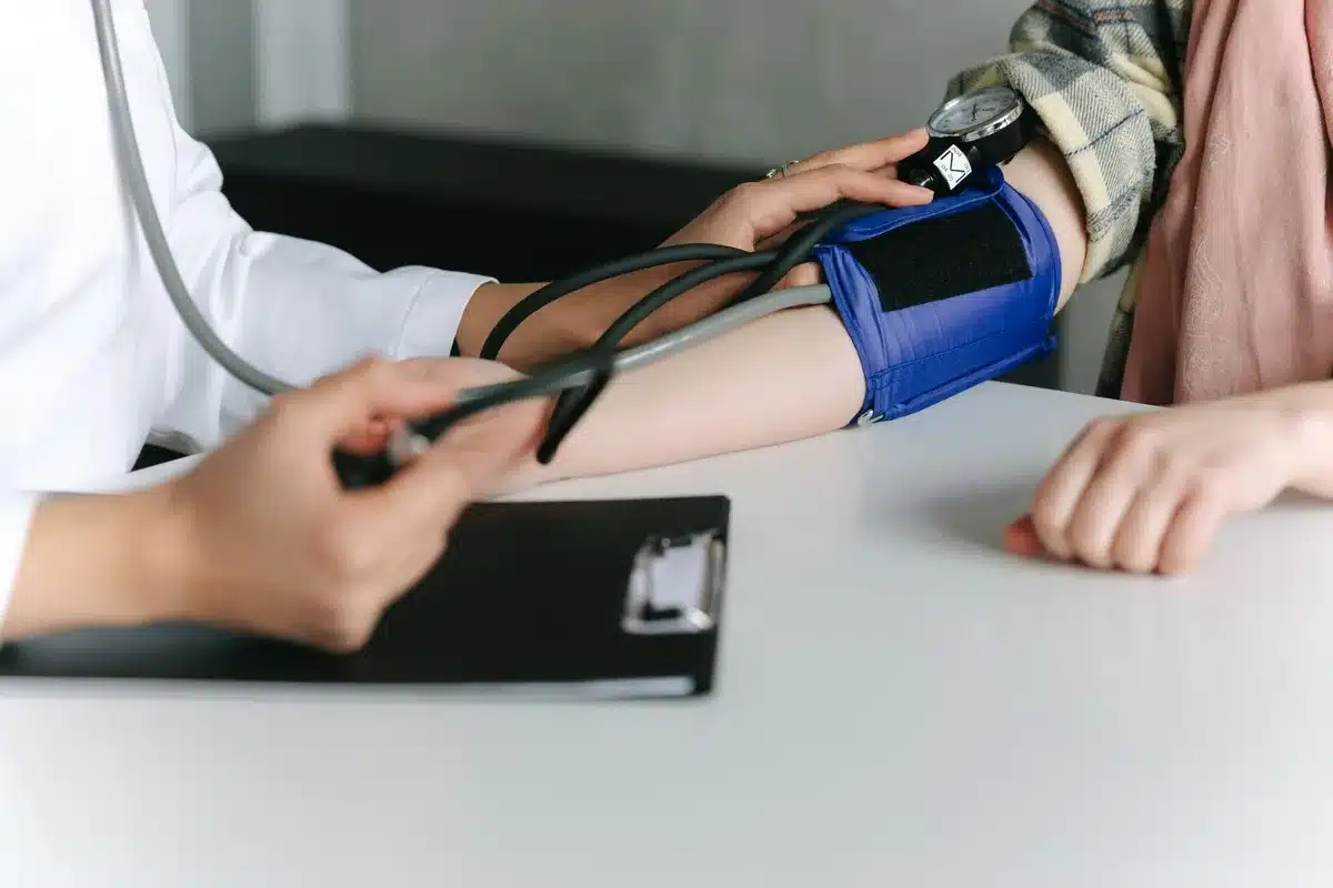 Médico en consulta con paciente discutiendo riesgos de salud y monitoreo médico