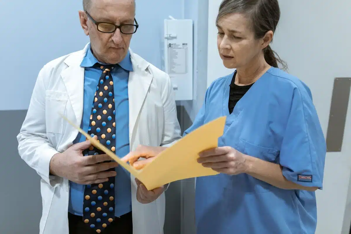A doctor reviewing medications and health records with a patient during a consultation.