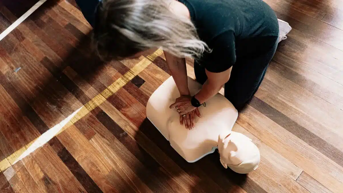 Instructor demonstrating chest compressions on a training dummy