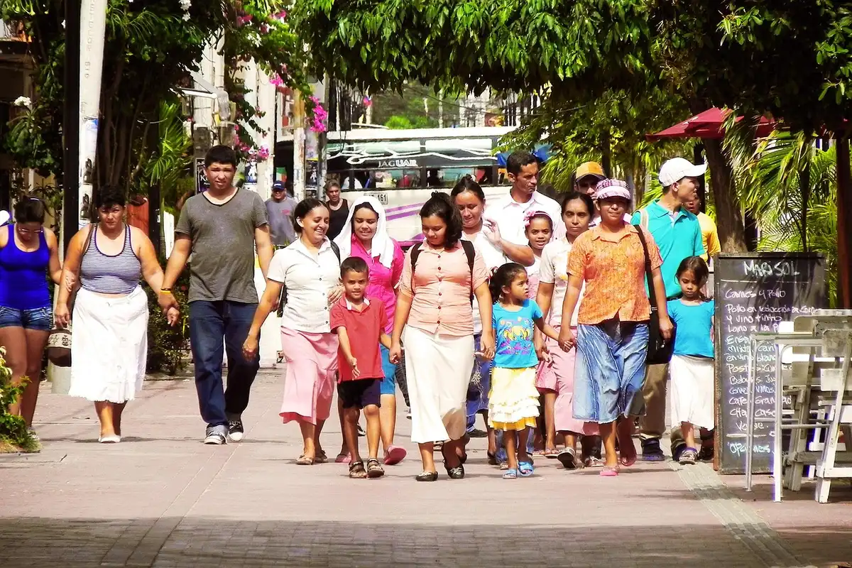 Older adult walking on a sunny neighborhood sidewalk with casual clothes
