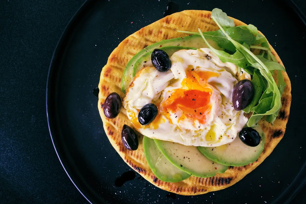 Petit-déjeuner équilibré avec œufs, avocat et pain complet