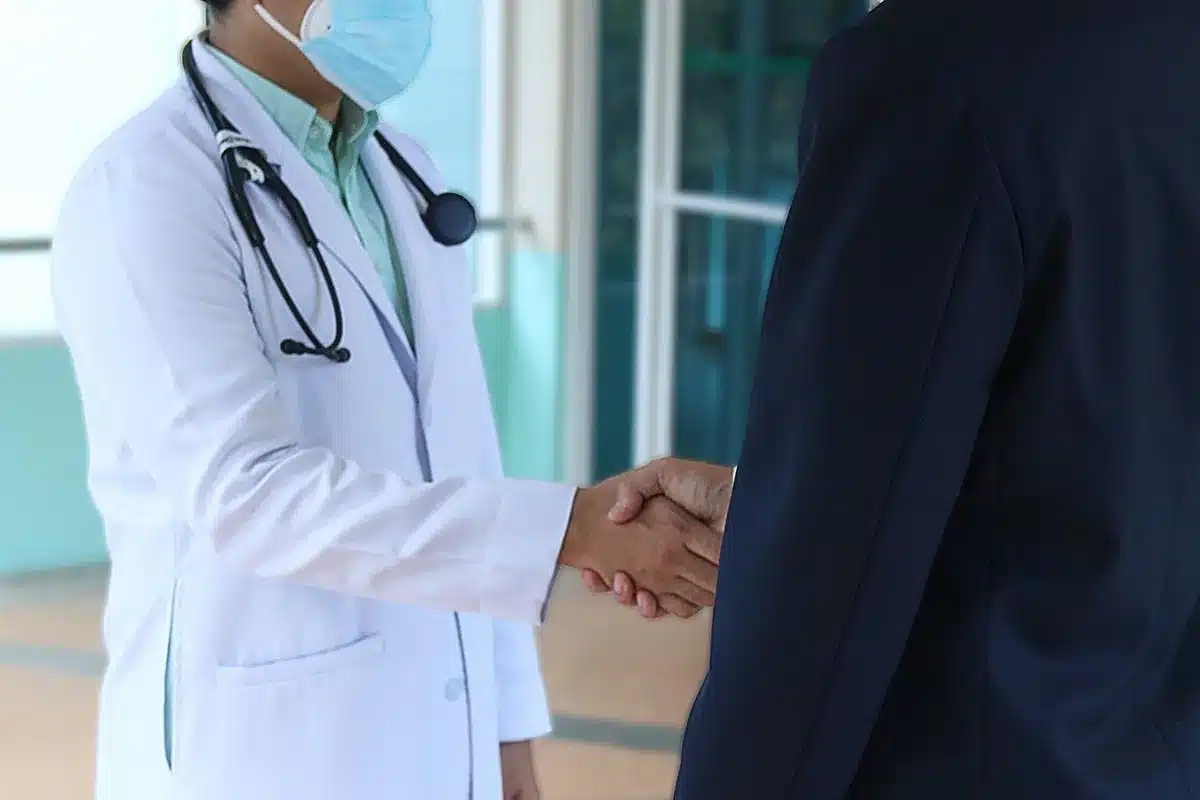 Hands holding a clinic appointment card in a bright exam waiting room