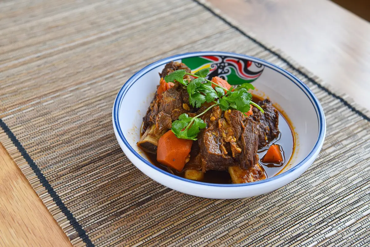 Bowl of braised chicken gizzards with herbs and sauce
