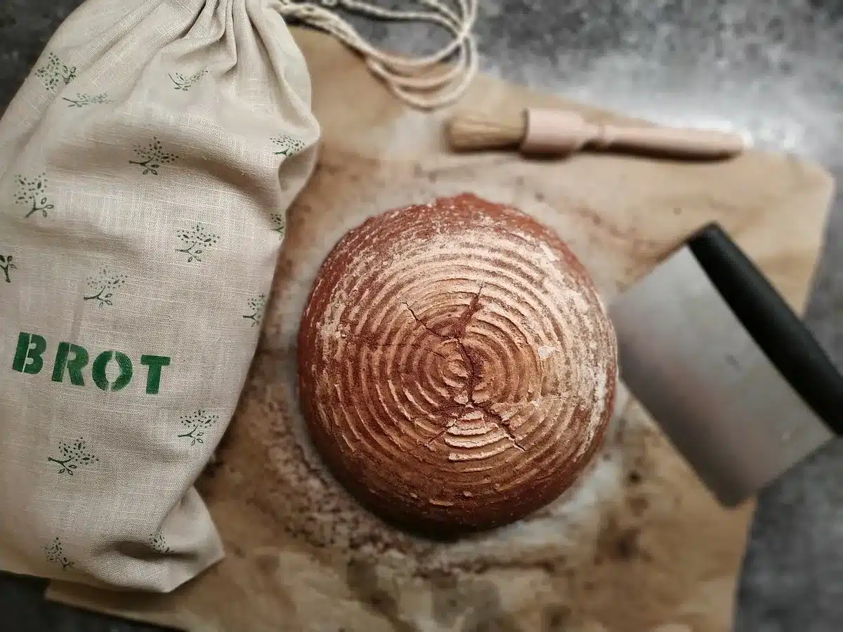 Hands placing sliced bread into airtight freezer bags on a sunny countertop