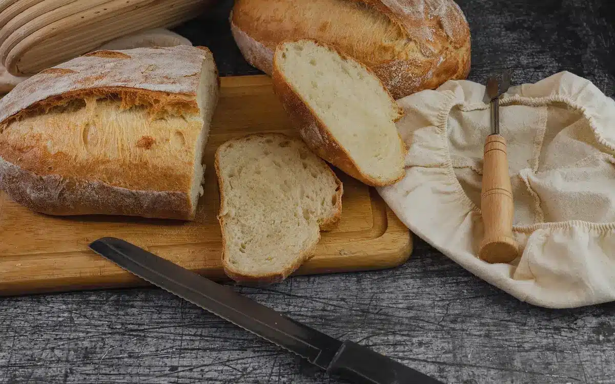 Sliced loaf wrapped in freezer bags on a sunny kitchen counter with a toaster nearby