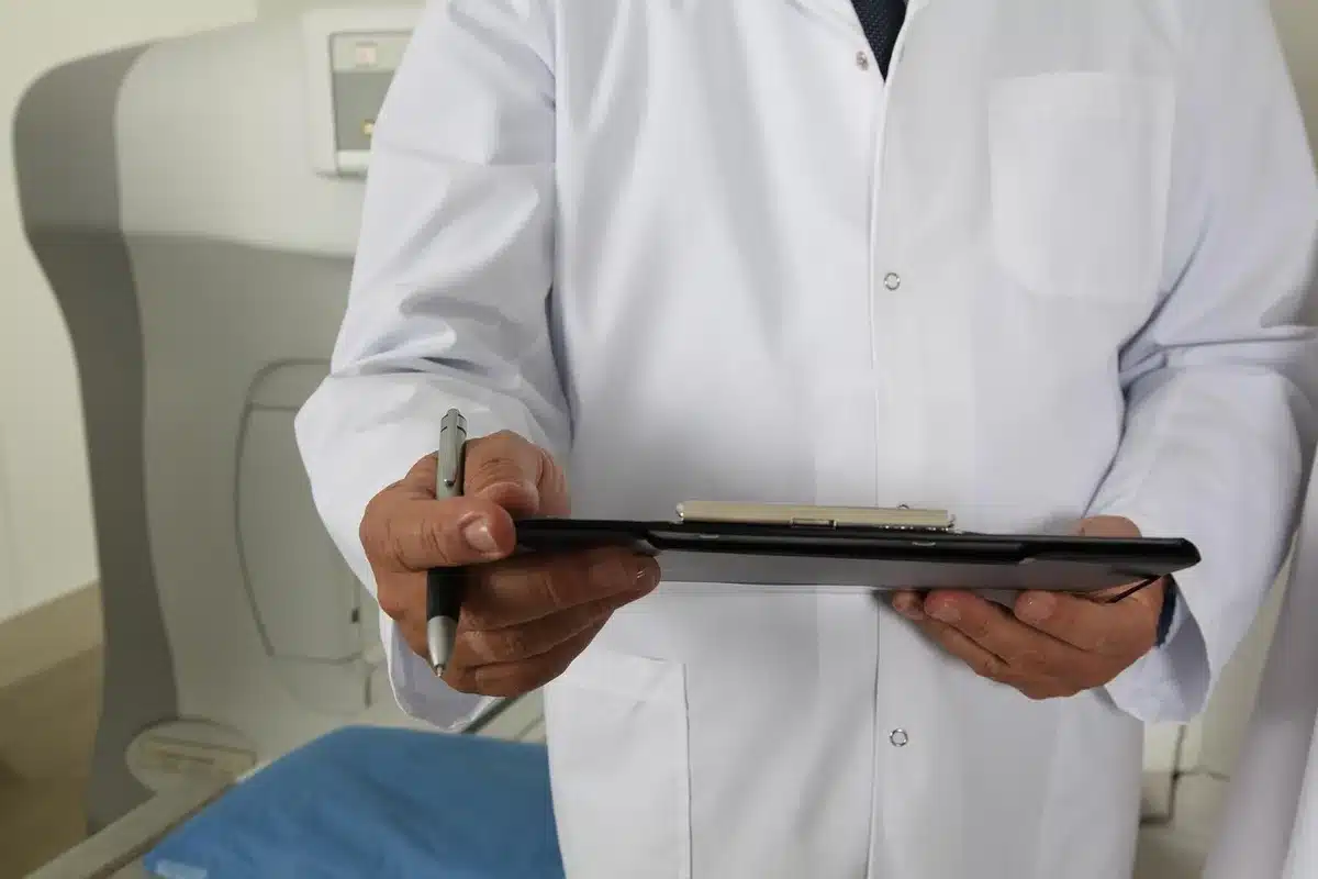 Two anonymous hands exchanging a prescription leaflet in a bright clinic